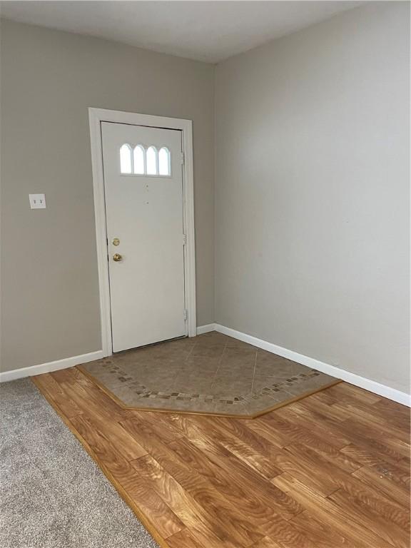 foyer featuring baseboards and wood finished floors