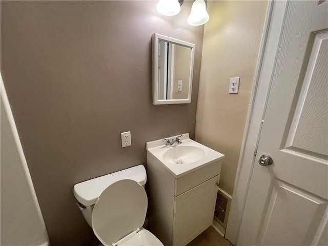 half bathroom with visible vents, toilet, and vanity