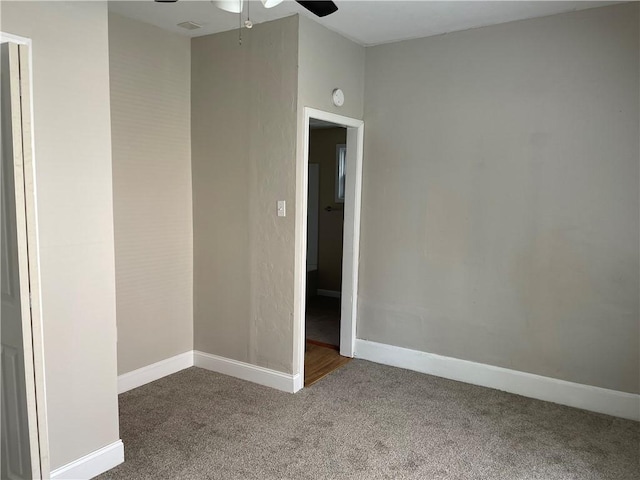 carpeted empty room featuring baseboards and ceiling fan