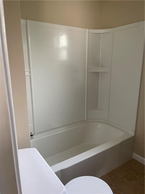 full bathroom with tile patterned floors, toilet, baseboards, and tub / shower combination