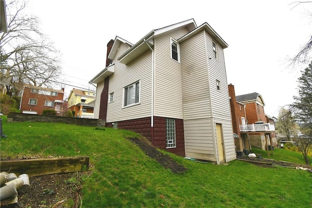rear view of house featuring a yard and a chimney