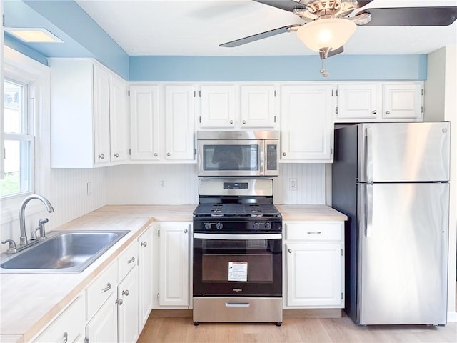 1138 Oakmont Ave, Oakmont, PA 15139 - kitchen featuring white cabinets, a sink, a ceiling fan, and appliances with stainless steel finishes