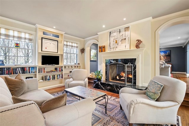 210 Creek Dr, Edgeworth, PA 15143 - living room with arched walkways, ornamental molding, wood finished floors, a high end fireplace, and recessed lighting