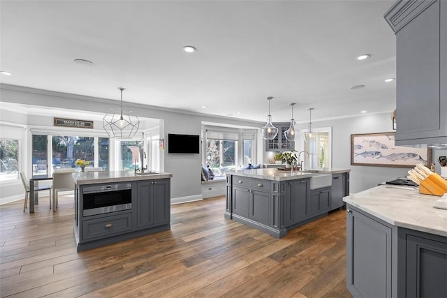 210 Creek Dr, Edgeworth, PA 15143 - kitchen featuring gray cabinetry, a center island with sink, a sink, crown molding, and dark wood-style flooring