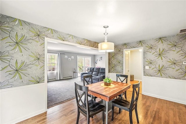 dining room with baseboards, light wood finished floors, and wallpapered walls