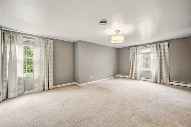 carpeted empty room with visible vents, baseboards, plenty of natural light, and baseboard heating