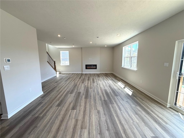406 Barons Ct, Peters Twp, PA 15367 - unfurnished living room with wood finished floors, baseboards, recessed lighting, stairway, and a glass covered fireplace