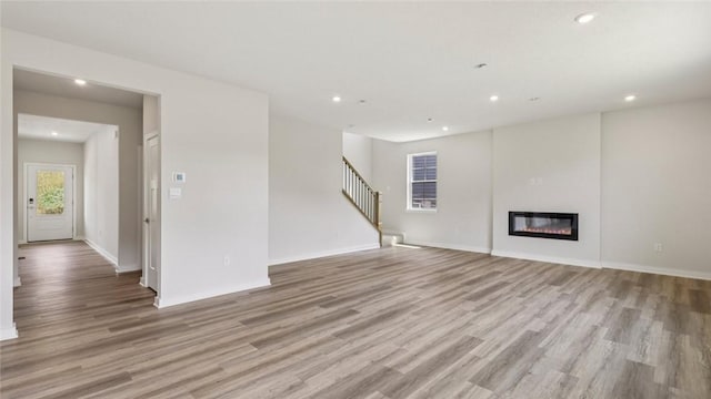 406 Barons Ct, Peters Twp, PA 15367 - unfurnished living room featuring wood finished floors, recessed lighting, stairs, and a glass covered fireplace