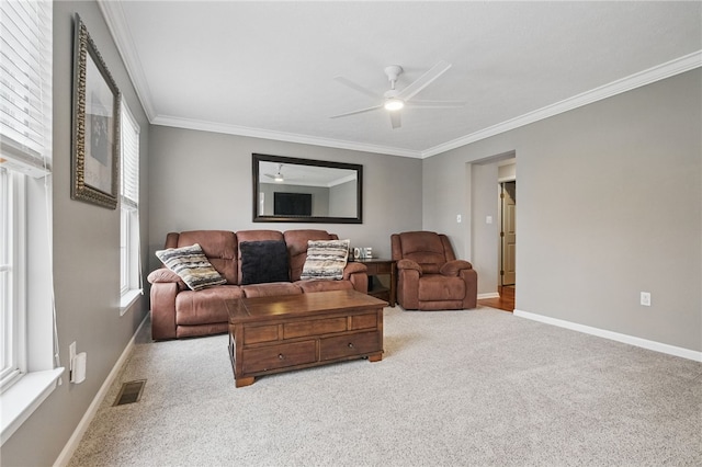 living area with ornamental molding, a ceiling fan, and carpet flooring