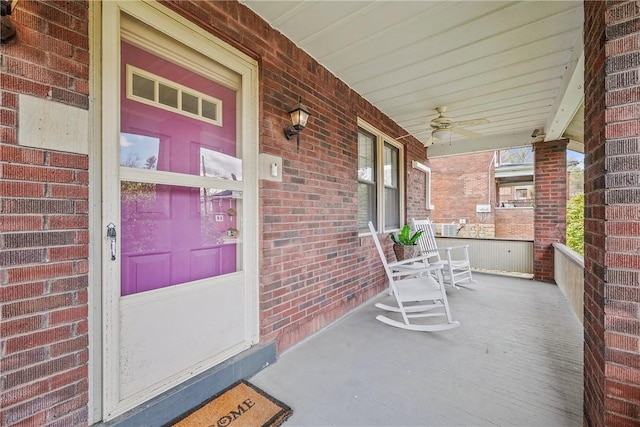 view of exterior entry featuring brick siding and a porch