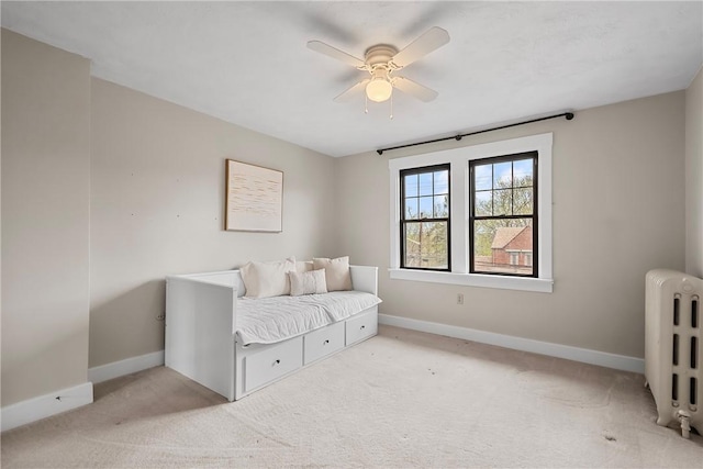 carpeted bedroom with radiator, baseboards, and a ceiling fan