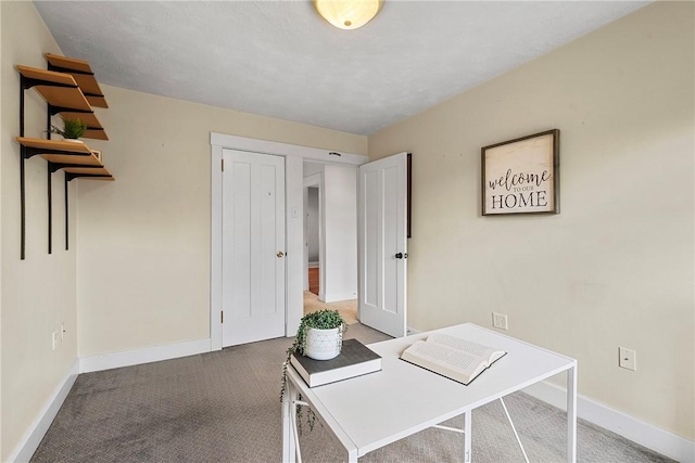 carpeted office featuring baseboards