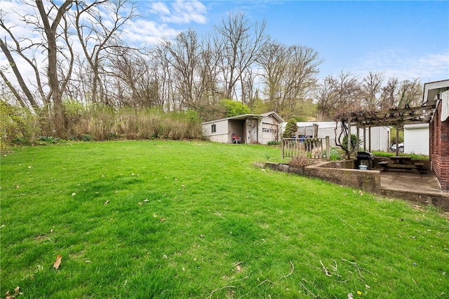 view of yard featuring a pergola and an outbuilding