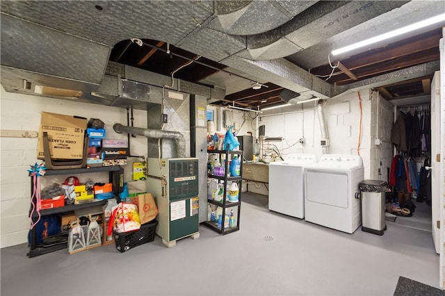 unfinished below grade area featuring concrete block wall and separate washer and dryer