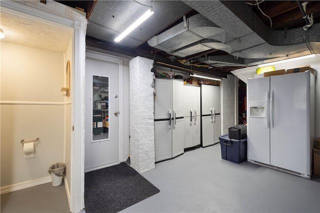 basement featuring white fridge with ice dispenser
