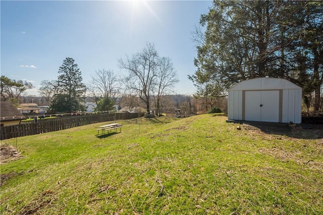 view of yard with a shed, fence, and an outdoor structure