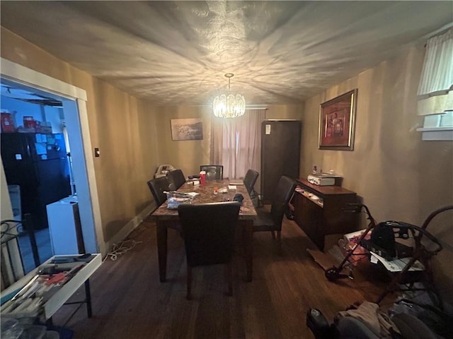 dining room with wood finished floors and a notable chandelier
