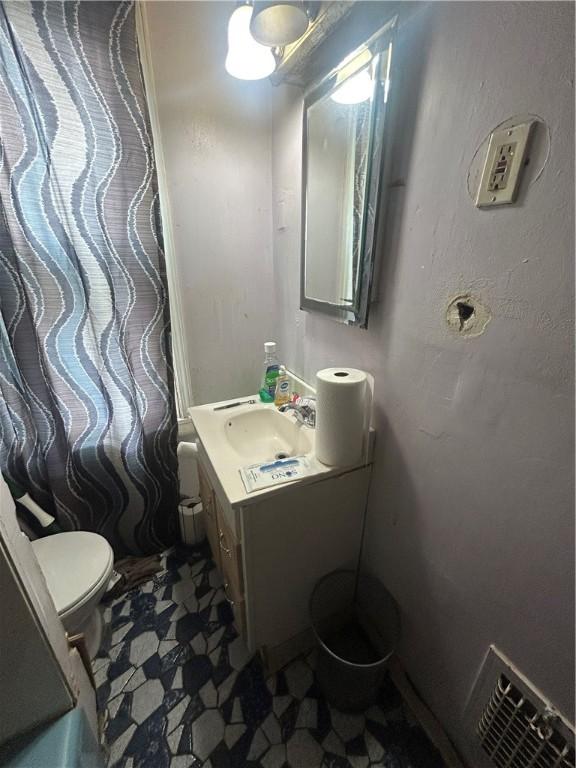 bathroom with tile patterned floors, toilet, vanity, and visible vents