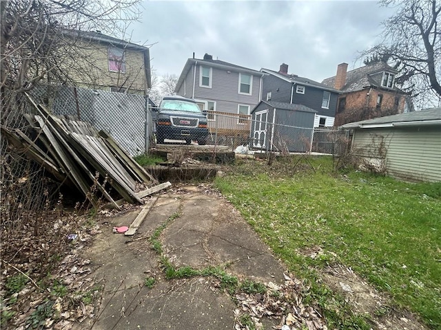 view of yard featuring an outbuilding, a shed, and fence