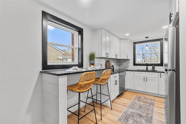 647 Northcrest Dr, Brookline, PA 15226 - kitchen featuring light wood-type flooring, white cabinetry, dark countertops, stainless steel appliances, and decorative backsplash
