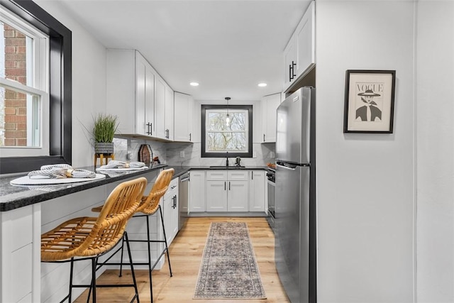647 Northcrest Dr, Brookline, PA 15226 - kitchen with recessed lighting, white cabinetry, dark countertops, light wood-style floors, and appliances with stainless steel finishes