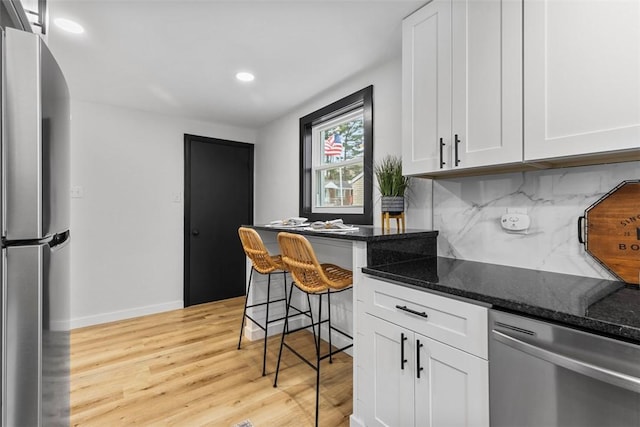 647 Northcrest Dr, Brookline, PA 15226 - kitchen featuring white cabinetry, dark stone countertops, stainless steel appliances, light wood finished floors, and backsplash