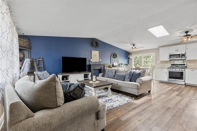 123 Summit Ridge Dr, South Fayette, PA 15017 - living area featuring light wood-style flooring, vaulted ceiling with skylight, and a ceiling fan