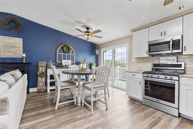 123 Summit Ridge Dr, South Fayette, PA 15017 - kitchen with light wood-type flooring, a textured wall, a ceiling fan, and stainless steel appliances