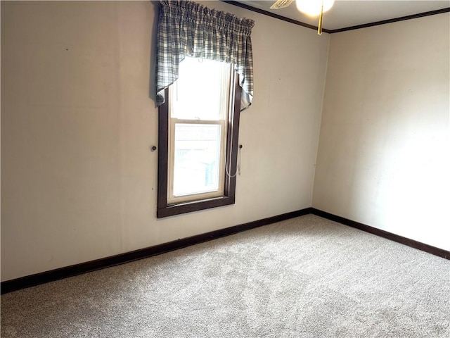 carpeted empty room with baseboards, crown molding, and ceiling fan