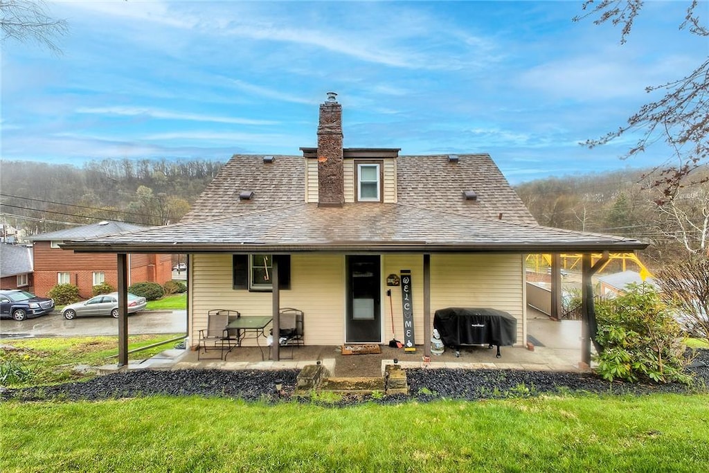11830 Shannon St, North Huntingdon, PA 15647 - rear view of house with roof with shingles, a chimney, a lawn, and covered porch