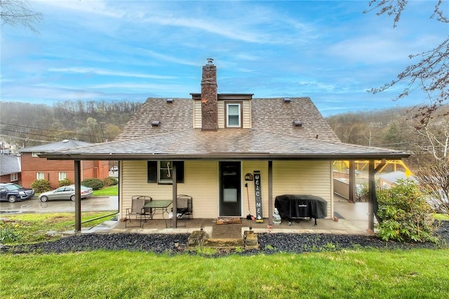 11830 Shannon St, North Huntingdon, PA 15647 - rear view of house with roof with shingles, a chimney, a lawn, and covered porch
