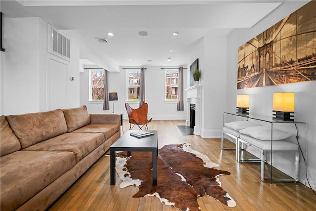 4721 Stanton Ave, Stanton Heights, PA 15201 - living room with light wood-style floors, a fireplace with flush hearth, visible vents, and baseboards