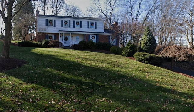 traditional home with a front lawn, a porch, and a chimney