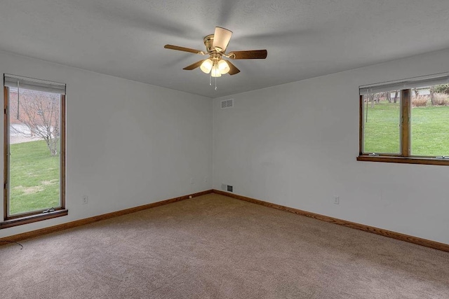 unfurnished room featuring carpet floors, plenty of natural light, and visible vents