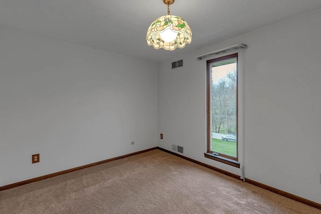 spare room featuring visible vents, baseboards, and carpet floors