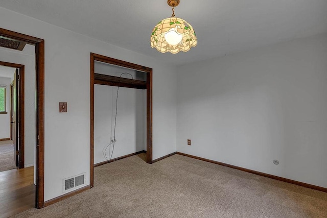 unfurnished bedroom with a closet, baseboards, carpet, and visible vents