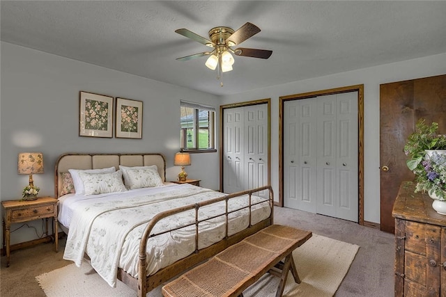 bedroom featuring baseboards, two closets, a ceiling fan, and light colored carpet