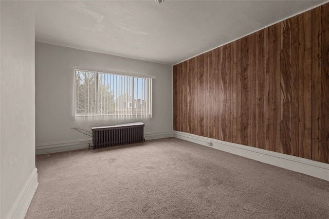 826 Collins Ave, Highland Park, PA 15206 - carpeted empty room featuring radiator, wooden walls, and baseboards
