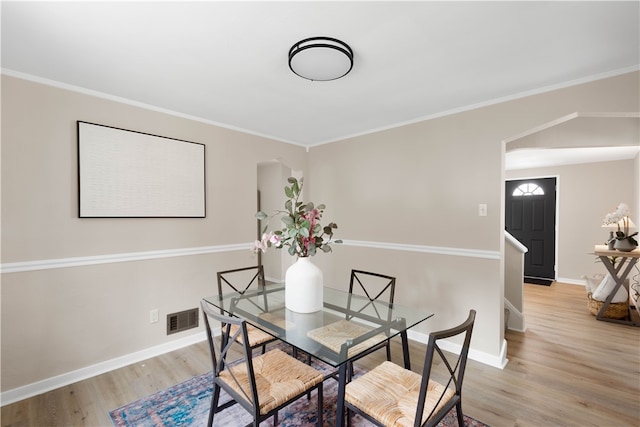 2011 Woodward Ave, Brookline, PA 15226 - dining area with crown molding, light wood-style flooring, arched walkways, visible vents, and baseboards