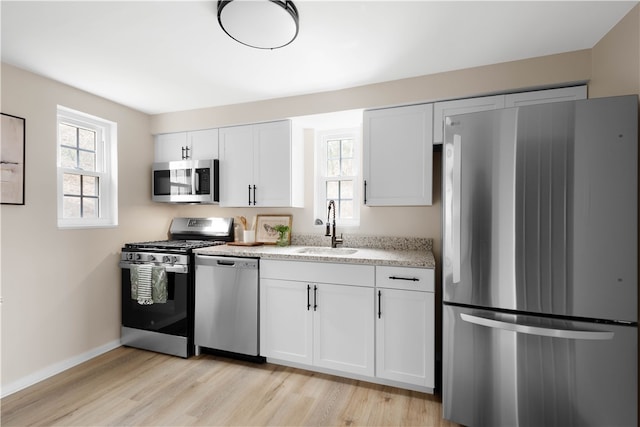 2011 Woodward Ave, Brookline, PA 15226 - kitchen with light wood-style flooring, appliances with stainless steel finishes, a sink, and white cabinetry