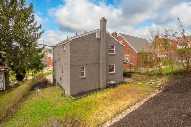 2011 Woodward Ave, Brookline, PA 15226 - back of house with a chimney, central AC unit, and a lawn