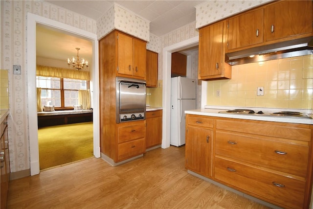 2714 Graham Blvd, Wilkinsburg, PA 15235 - kitchen with light wood-type flooring, freestanding refrigerator, under cabinet range hood, brown cabinetry, and wallpapered walls