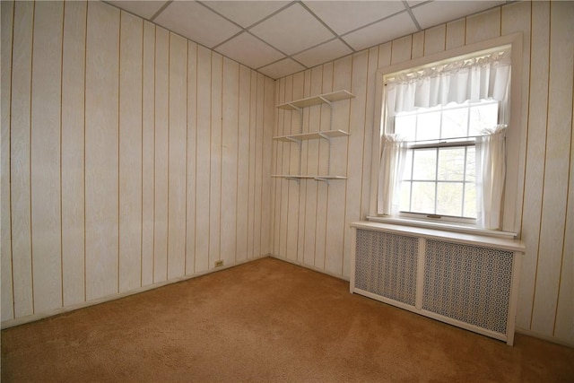 2714 Graham Blvd, Wilkinsburg, PA 15235 - carpeted empty room featuring radiator, wood walls, and a drop ceiling