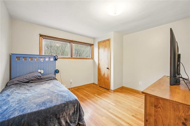 bedroom with light wood finished floors and baseboards