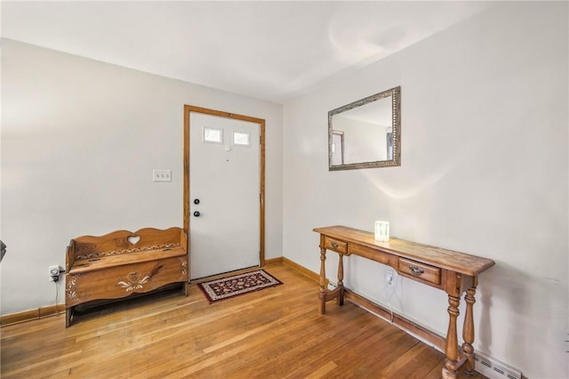 entryway with baseboard heating, baseboards, and wood finished floors