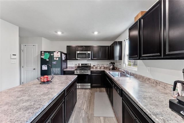 106 Morgan Dr, South Strabane, PA 15301 - kitchen featuring a sink, light wood-type flooring, dark cabinetry, light countertops, and appliances with stainless steel finishes