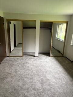 unfurnished bedroom featuring multiple closets