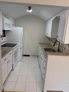 kitchen featuring white cabinets, lofted ceiling, light tile patterned floors, a sink, and white appliances