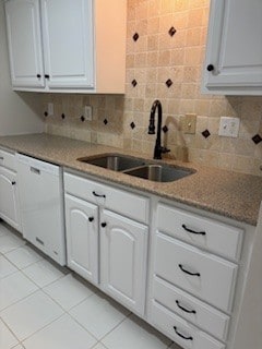 kitchen with dishwasher, decorative backsplash, a sink, and light tile patterned floors