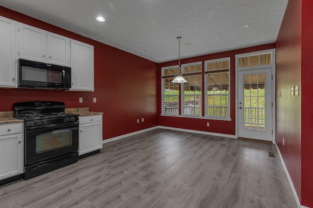 kitchen with black appliances, white cabinets, light wood-type flooring, baseboards, and a textured ceiling